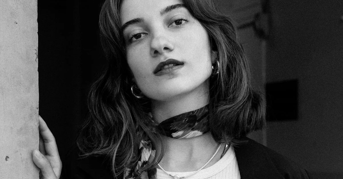 Photographie portrait stylée en noir et blanc d'une femme avec un foulard, incarnant l'élégance et la mode.